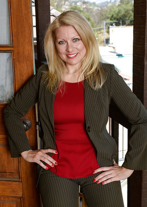 Barely clothed mature blonde in stockings revealing her round boobs